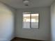 Neutral bedroom showcasing a window, neutral walls and wood-look tile flooring at 18361 W Jessie Ln, Surprise, AZ 85387