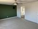 Bedroom with green wall, ceiling fan, and bathroom at 18361 W Jessie Ln, Surprise, AZ 85387