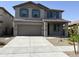 Two-story home showcasing a grey exterior, brown garage door, blue shutters and a well maintained lawn at 18361 W Jessie Ln, Surprise, AZ 85387