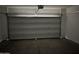 An empty garage with a closed garage door at 18361 W Jessie Ln, Surprise, AZ 85387