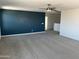 Open living room with blue accent wall and large ceiling fan at 18361 W Jessie Ln, Surprise, AZ 85387