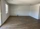 Spacious living room with wood-look tile flooring and bright natural light at 18361 W Jessie Ln, Surprise, AZ 85387