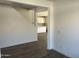 Bright room with wood-look tile flooring, white walls, leading into the kitchen at 18361 W Jessie Ln, Surprise, AZ 85387