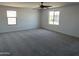 Large main bedroom featuring a ceiling fan and two windows at 18361 W Jessie Ln, Surprise, AZ 85387