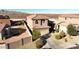 Aerial view of a terracotta roof home with a two-car garage, lush landscaping, and a fenced backyard at 19886 W Woodlands Ave, Buckeye, AZ 85326