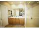 Bathroom featuring a double sink vanity, brown cabinets, and a shower at 19886 W Woodlands Ave, Buckeye, AZ 85326