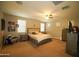 Bedroom featuring carpeted floors, windows, a ceiling fan, and a bed at 19886 W Woodlands Ave, Buckeye, AZ 85326