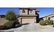 Charming home featuring a two-car garage, arched windows, and well-maintained landscaping at 19886 W Woodlands Ave, Buckeye, AZ 85326