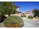 Attractive home showcasing a two-car garage, manicured landscaping, and healthy, green shrubbery at 19886 W Woodlands Ave, Buckeye, AZ 85326