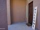 Inviting front porch with a dark brown front door, 'Welcome' sign, and stucco walls at 19886 W Woodlands Ave, Buckeye, AZ 85326
