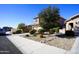 Landscaped front yard with decorative stones and bushes; the property has a two-car garage at 19886 W Woodlands Ave, Buckeye, AZ 85326