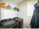 Functional laundry room with white subway tile backsplash and modern machines at 19886 W Woodlands Ave, Buckeye, AZ 85326