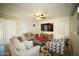 Comfortable living room featuring tile floors, a ceiling fan, and large TV at 19886 W Woodlands Ave, Buckeye, AZ 85326