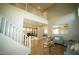 Bright living room with high ceilings, wood floors, a staircase, and blue couches at 19886 W Woodlands Ave, Buckeye, AZ 85326