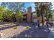 Exterior view of a multi-story building with balconies, surrounded by mature trees and gravel landscaping at 200 E Southern Ave # 226, Tempe, AZ 85282