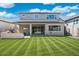 Backyard with covered patio, outdoor kitchen with grill, blue fire pit, and green grass at 21134 W Minnezona Ave, Buckeye, AZ 85396