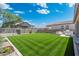 Expansive backyard featuring lush green grass, beautiful landscaping, outdoor kitchen, and a clear blue sky at 21134 W Minnezona Ave, Buckeye, AZ 85396