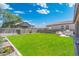 Large backyard featuring a green lawn, outdoor kitchen and fenced-in side yard at 21134 W Minnezona Ave, Buckeye, AZ 85396