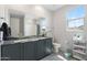 Stylish bathroom with dual sinks, patterned floors, and modern fixtures offering comfort and convenience at 21134 W Minnezona Ave, Buckeye, AZ 85396