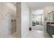 Modern bathroom layout showcases a tiled shower, neutral vanity, and an open doorway into main bedroom at 21134 W Minnezona Ave, Buckeye, AZ 85396