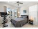 Comfortable bedroom with a queen bed, bright natural light from the large windows, and modern ceiling fan at 21134 W Minnezona Ave, Buckeye, AZ 85396