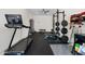 Home gym featuring modern exercise equipment including treadmill, weight rack, and bench on rubber floor at 21134 W Minnezona Ave, Buckeye, AZ 85396