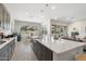 Open concept kitchen features an island, granite countertops, gray cabinetry, and is connected to the dining and living area at 21134 W Minnezona Ave, Buckeye, AZ 85396