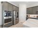 A modern kitchen featuring stainless steel appliances and gray cabinets at 21134 W Minnezona Ave, Buckeye, AZ 85396