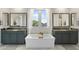 Bright and airy main bathroom equipped with a soaking tub, double sinks, and stylish mirrors at 21134 W Minnezona Ave, Buckeye, AZ 85396