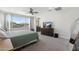 Well-lit main bedroom boasts a neutral color palette, carpet, TV, ceiling fan, and ample closet space at 21134 W Minnezona Ave, Buckeye, AZ 85396
