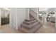 Staircase leading to the upper level with a carpeted steps and white banister at 21134 W Minnezona Ave, Buckeye, AZ 85396