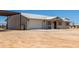 One-story home with metal roof, desert landscaping, covered porch, and attached garage at 22578 E Sahara Dr, Florence, AZ 85132