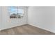 Bedroom with neutral carpet, bright light, white walls, and a view of other houses at 22580 N Lynn St, Maricopa, AZ 85138