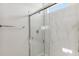 Bathroom featuring a shower with glass doors and white marble-style walls and a chrome towel bar at 25478 W Graham Trl, Buckeye, AZ 85326