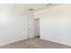 Bright bedroom with neutral carpet, white walls, and a doorway to another room at 25478 W Graham Trl, Buckeye, AZ 85326