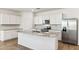 Modern kitchen features an island, granite countertops, stainless steel appliances, and white cabinets at 25478 W Graham Trl, Buckeye, AZ 85326