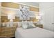 Inviting bedroom with stylish décor, linen bedding, modern nightstands and striped accent wall at 25481 W Graham Trl, Buckeye, AZ 85326
