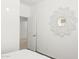 Bright bedroom with an open door, simple white walls, and modern, geometric mirror at 25481 W Graham Trl, Buckeye, AZ 85326