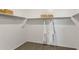 Spacious walk-in closet with built-in shelving, clothes rods, and neutral carpeting at 25481 W Graham Trl, Buckeye, AZ 85326