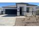 Charming single-story home featuring stone accents, a well-maintained front yard, and an attached two-car garage at 25481 W Graham Trl, Buckeye, AZ 85326