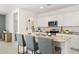 Bright kitchen features white cabinets, stainless steel appliances, and granite countertops with seating at the island at 25481 W Graham Trl, Buckeye, AZ 85326