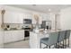 Modern kitchen with white cabinets, stainless steel appliances, granite countertops, and a convenient island with barstool seating at 25481 W Graham Trl, Buckeye, AZ 85326