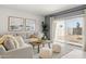 Cozy living room featuring neutral tones, stylish decor, comfortable seating, and sliding glass doors to the backyard at 25481 W Graham Trl, Buckeye, AZ 85326