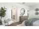 Bright main bedroom with a dresser and chair, a view of the ensuite, and a neutral color scheme at 25481 W Graham Trl, Buckeye, AZ 85326