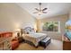 Spacious main bedroom with a ceiling fan and a large window offering views of the lush greenery at 3350 E Rosemonte Dr, Phoenix, AZ 85050