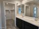 Bathroom with double vanity, large mirrors, and a door to walk-in closet and toilet shower at 3354 S 180Th Ln, Goodyear, AZ 85338