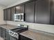 Close up view of a kitchen, featuring stainless steel appliances, granite countertops, and dark wood cabinets at 3354 S 180Th Ln, Goodyear, AZ 85338