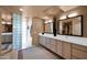 Bright bathroom with double sinks, vanities and a walk-in glass block shower at 35180 N Boulder Pass, Scottsdale, AZ 85266