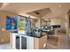 Open concept kitchen with sleek countertops, island and breakfast bar, flowing into the dining area at 35180 N Boulder Pass, Scottsdale, AZ 85266