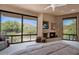 Bright main bedroom with large windows showcasing desert views, a fireplace, and comfortable seating at 35180 N Boulder Pass, Scottsdale, AZ 85266
